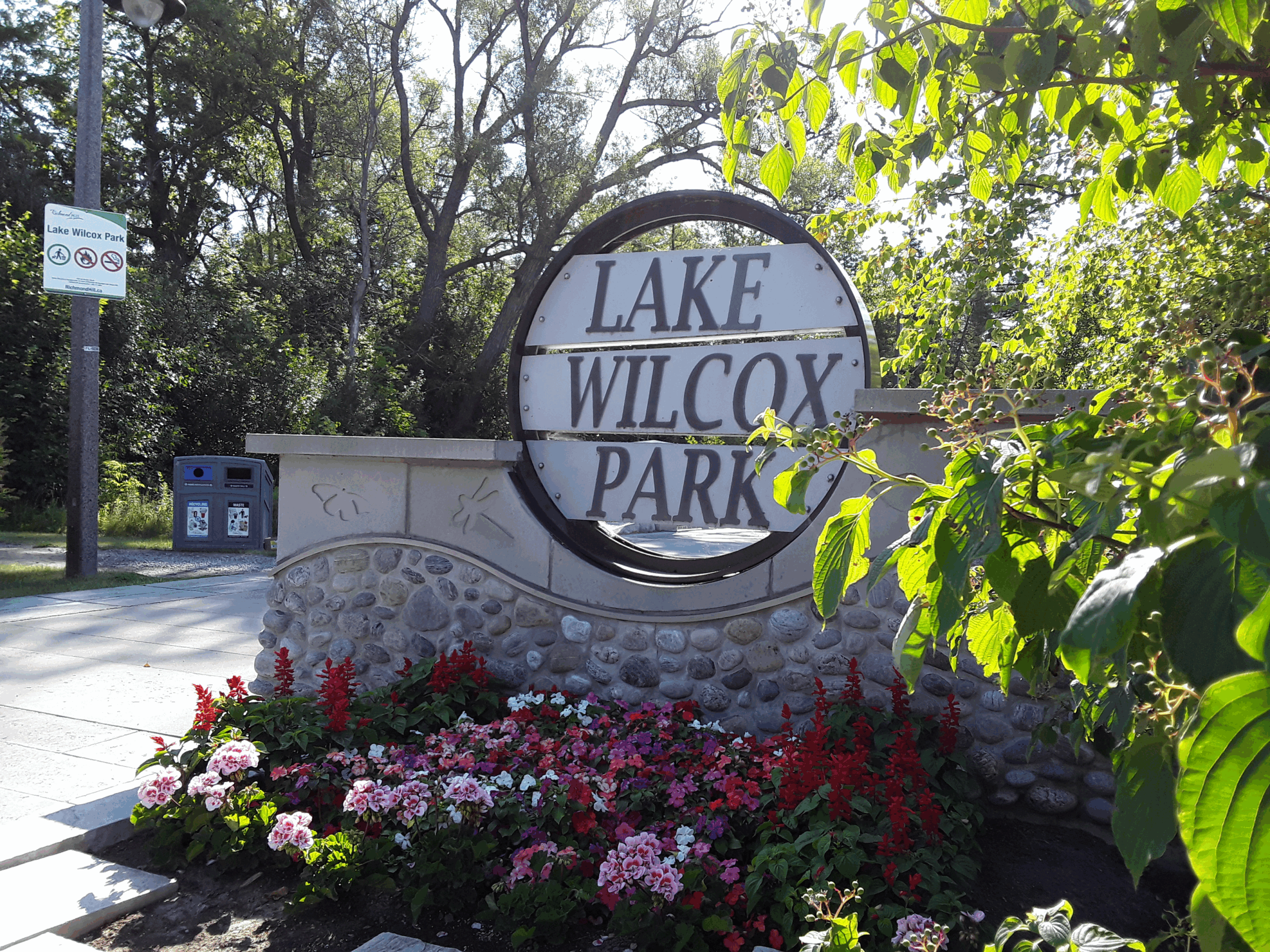 Sign for Lake Wilcox Park looking south from Old Bayview Avenue before entering the relatively new walkway with flowers